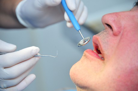 Odontologas ruošiasi apžiūrėti dantis